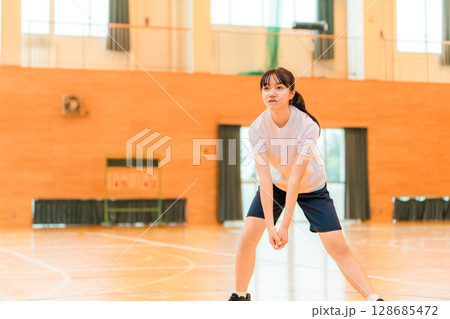 体育館でバレーボールをする体操着姿の女子中学生・女子高生 128685472