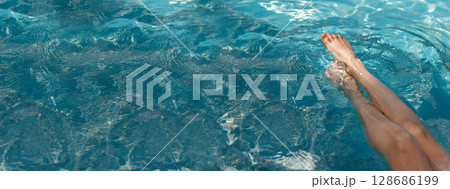 A girl's feet in a blue pool. Epilation of legs, varicose veins. Rest, relaxation on the beach, at the hotel. A woman in freedom. Vacation. High quality photo 128686199