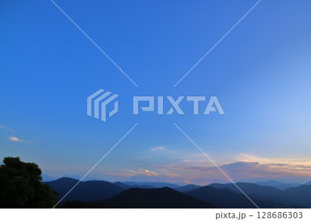 夕焼け空　青空　雲　飛行機雲　樹木　山地 128686303