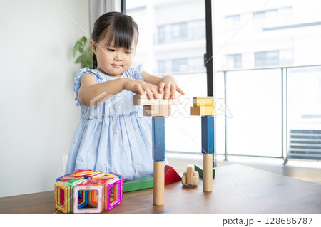 積み木で遊ぶ幼い女の子の知育風景 128686787