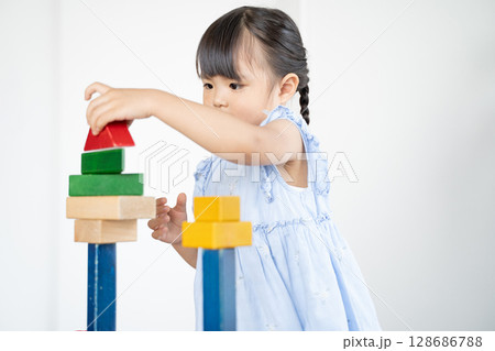 積み木で遊ぶ幼い女の子の知育風景 積み木で遊ぶ幼い女の子の知育風景 128686788