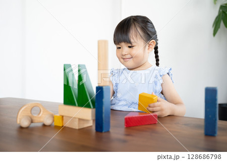 積み木で遊ぶ幼い女の子の知育風景 積み木で遊ぶ幼い女の子の知育風景 128686798