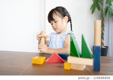 積み木で遊ぶ幼い女の子の知育風景 128686808
