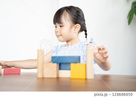 積み木で遊ぶ幼い女の子の知育風景 積み木で遊ぶ幼い女の子の知育風景 128686850
