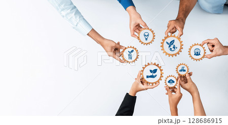 Hands Collaborating on Eco-Friendly Business Solutions with Gear Icons, Symbolizing Sustainability, Innovation, and Growth in a Green Economy Concept. Amity Hands Collaborating on Eco-Friendly Business Solutions with Gear Icons, Symbolizing Sustainability, Innovation, and Growth in a Green Economy Concept. Amity 128686915