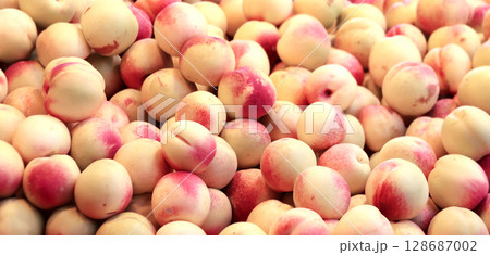 Horizontal full background with ripe nectarines. Fresh nectarine for sale on street market, Southeast Asia. Fresh fruits in a traditional morning market, Myanmar 128687002