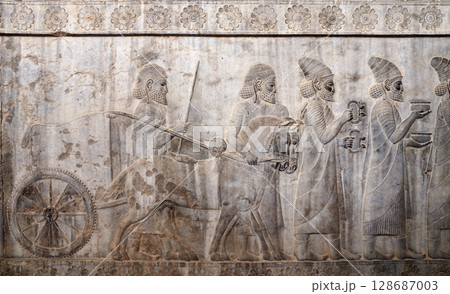 Ancient wall with bas-relief with assyrian warriors, horses and foreign ambassadors with gifts and donations, Persepolis, Iran. Topic of travel, trip abroad on vacation, cruises and tours 128687003