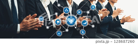Business Meeting with Applause and Technology Icons Depicting Collaboration and Innovation in a Corporate Setting with Professionals in Suits. Amity Business Meeting with Applause and Technology Icons Depicting Collaboration and Innovation in a Corporate Setting with Professionals in Suits. Amity 128687260