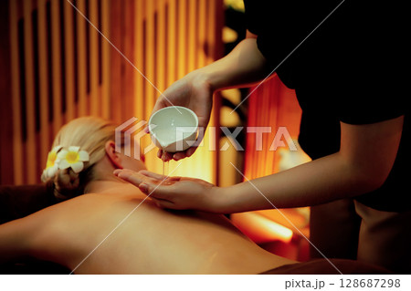 Masseuse prepare oil massage procedure for customer at spa. Quiescent Masseuse prepare oil massage procedure for customer at spa. Quiescent 128687298