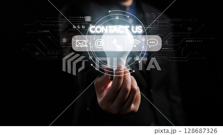 Businessman Holding Light Bulb with Contact Us Icons in Modern Digital Interface for Innovative Communication and Networking Solutions. Qubit Businessman Holding Light Bulb with Contact Us Icons in Modern Digital Interface for Innovative Communication and Networking Solutions. Qubit 128687326