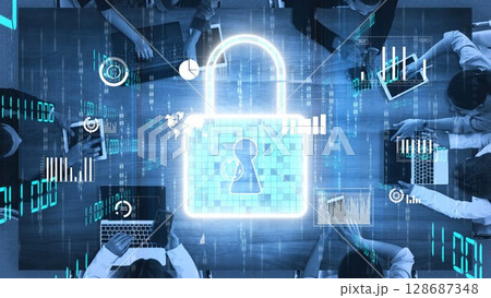 Abstract representation of cyber security with digital lock symbol overlaid on a workspace featuring laptops, charts, and data analytics visualizations xenic 128687348