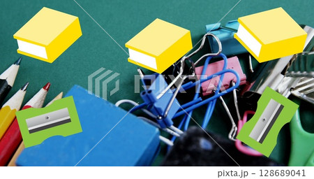 Image of green pencil sharpeners and yellow books moving over assorted school stationery Image of green pencil sharpeners and yellow books moving over assorted school stationery 128689041