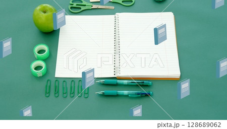 Image of blue schoolbooks moving over notebook and school stationery on desk 128689062