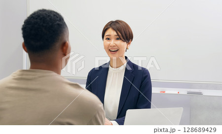 黒人男性と面談する日本人女性スタッフ 黒人男性と面談する日本人女性スタッフ 128689429
