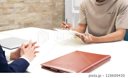 面談する黒人男性と日本人女性スタッフ 128689430