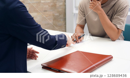 面談する黒人男性と日本人女性スタッフ 128689436