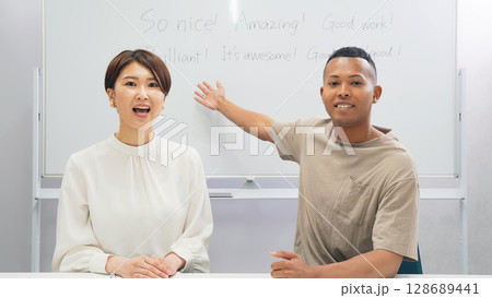 教室で授業する黒人男性と日本人女性 128689441