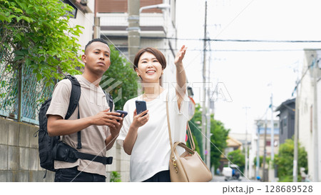 スマホを持って黒人男性に道案内する日本人女性 128689528