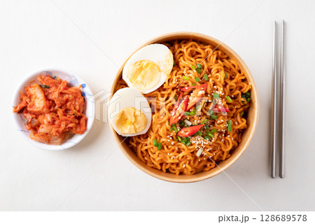 Spicy Korean dried instant noodles with boiled egg, scallions, sesame seed and chili  128689578