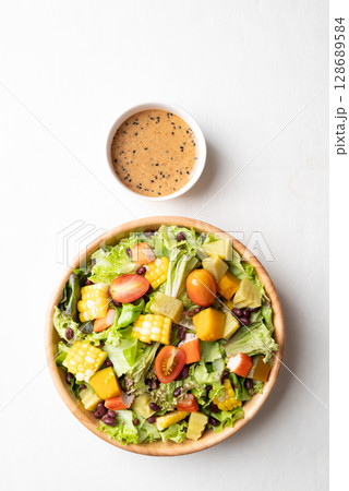 Top view of colorful vegetable salad in a bowl with Japanese sesame dressing  128689584