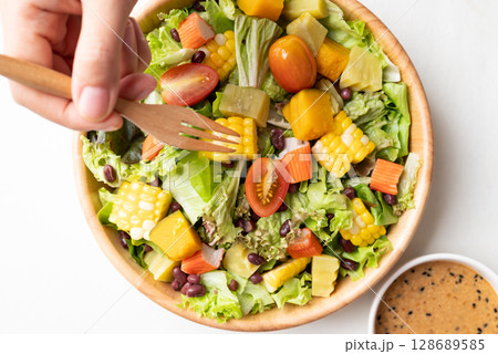 Top view of colorful vegetable salad in bowl with Japanese sesame dressing 128689585