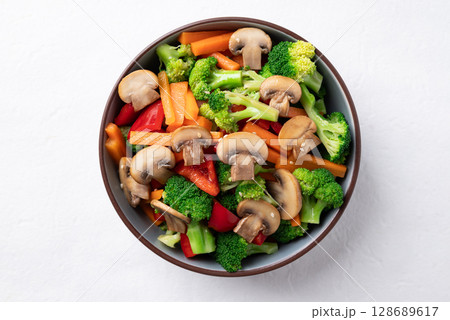 Stir fried vegetables, champignon mushroom, broccoli, bell pepper and carrot with soy sauce Stir fried vegetables, champignon mushroom, broccoli, bell pepper and carrot with soy sauce 128689617