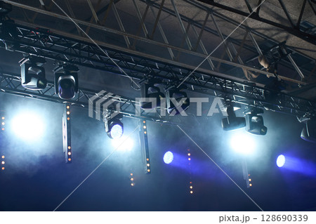 Stage with bright concert lighting, spotlights and smoke effects prepared for live music performance. Illumination for music event 128690339