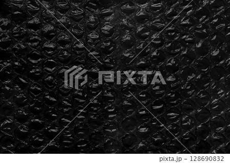 Black bubble wrap texture. Aged packaging material. Dark grunge abstract background Black bubble wrap texture. Aged packaging material. Dark grunge abstract background 128690832