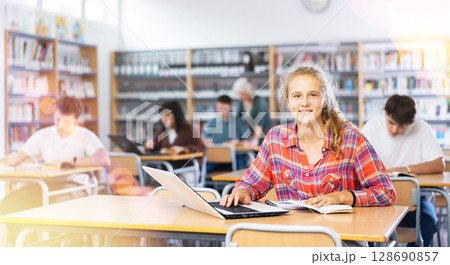 Portrait of diligent college girl studying using laptop Portrait of diligent college girl studying using laptop 128690857