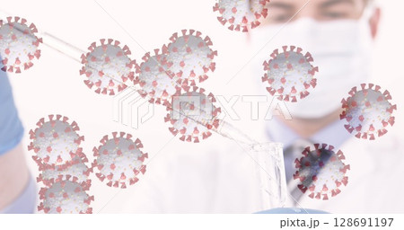 Two lab scientists transferring clear liquid sample using pipette in lab with coronavirus icons Two lab scientists transferring clear liquid sample using pipette in lab with coronavirus icons 128691197