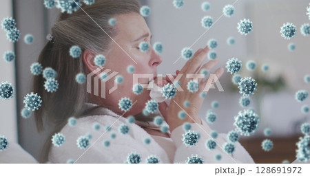 Sneezing mature woman holding crumpled tissue in softly lit home, with floating virus particles Sneezing mature woman holding crumpled tissue in softly lit home, with floating virus particles 128691972