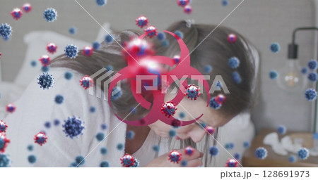 Leaning mature woman holding tissue over bed in bedroom, with viruses and biohazard symbol Leaning mature woman holding tissue over bed in bedroom, with viruses and biohazard symbol 128691973