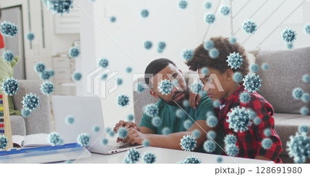 Father and son exploring virus particle overlays on silver laptop in living room, with abacus toy Father and son exploring virus particle overlays on silver laptop in living room, with abacus toy 128691980