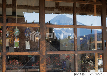 茅葺き屋根の古民家越しの秋の早朝の富士山 茅葺き屋根の古民家越しの秋の早朝の富士山 128692742