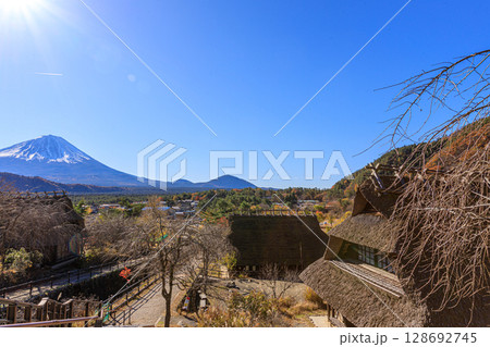茅葺き屋根の古民家越しの秋の早朝の富士山 茅葺き屋根の古民家越しの秋の早朝の富士山 128692745