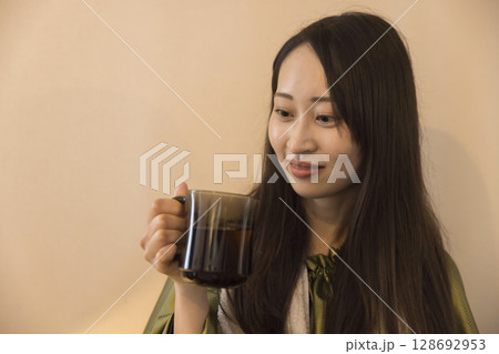 よもぎ蒸しをしながら水分補給をする女性イメージ よもぎ蒸しをしながら水分補給をする女性イメージ 128692953