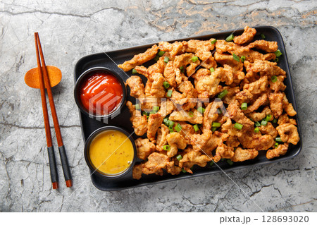 Sichuan Pepper Studded Crispy Pork Xiaosurou closeup on the plate. Horizontal top view Sichuan Pepper Studded Crispy Pork Xiaosurou closeup on the plate. Horizontal top view 128693020