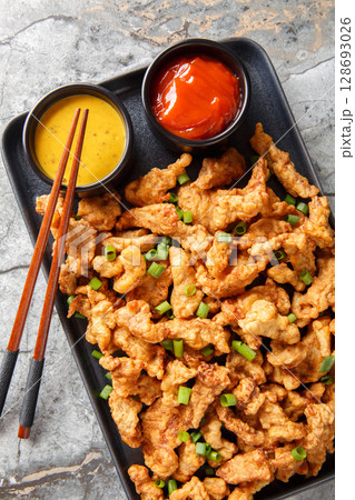 Xiaosurou Chinese Food Little Crispy Pork strips closeup on the plate on the table. Vertical top view Xiaosurou Chinese Food Little Crispy Pork strips closeup on the plate on the table. Vertical top view 128693026