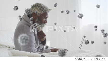 Image of virus cells over african american man using laptop Image of virus cells over african american man using laptop 128693344