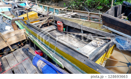 Close-Up of Traditional Wooden Fishing Boat with Gear and Engine on Tropical River Close-Up of Traditional Wooden Fishing Boat with Gear and Engine on Tropical River 128693663