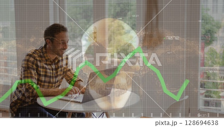 Image of financial data and skull over caucasian businessman working on laptop 128694638