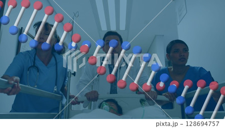 Image of dna over diverse female and male doctors running with bed with unconscious patient 128694757