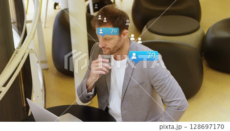 Images of falling social media icons over caucasian men using laptop 128697170