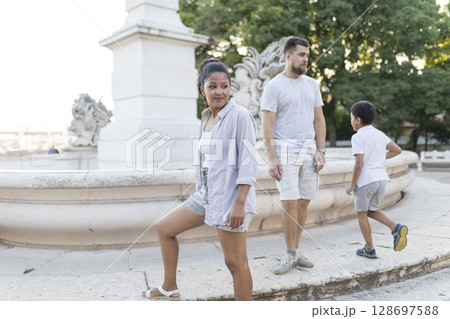 Family enjoying vacation posing by fountain in lisbon 128697588