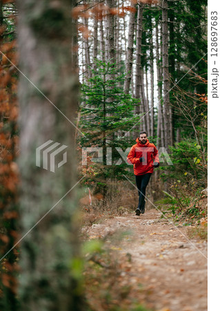 Jogger in Autumn Forest Trail Jogger in Autumn Forest Trail 128697683