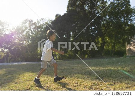 Happy child running and playing in a sunny park during summer Happy child running and playing in a sunny park during summer 128697721