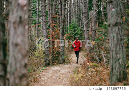 Jogger in Autumn Forest Trail 128697736