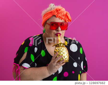 Stylish Woman with Pineapple Drink Against Pink Background 128697882
