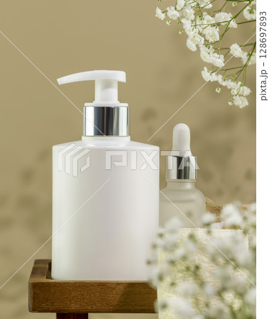 Eco friendly spa relax composition with mockup of beauty product in dispenser bottle on wooden podium with flowers. Wellness and skin care treatment. Concept of me time, self care. Vertical format Eco friendly spa relax composition with mockup of beauty product in dispenser bottle on wooden podium with flowers. Wellness and skin care treatment. Concept of me time, self care. Vertical format 128697893