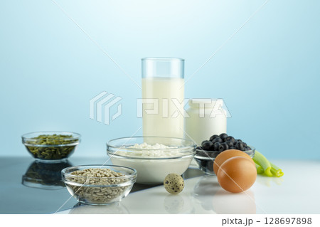 Food with calcium for health bones and joints. Products rich in calcium, supplements and X-ray film on white table. Healthy eating. Food for healthy bones, calcium source. Fronte view 128697898